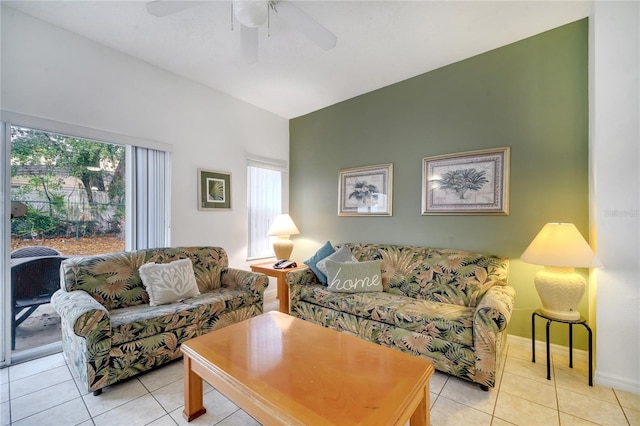 living room with ceiling fan, baseboards, and light tile patterned floors