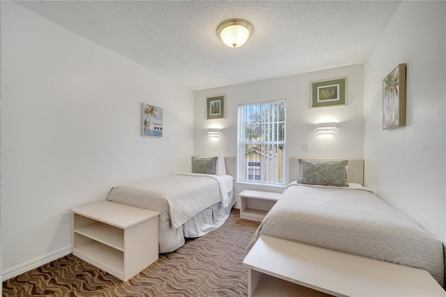 carpeted bedroom with baseboards and a textured ceiling