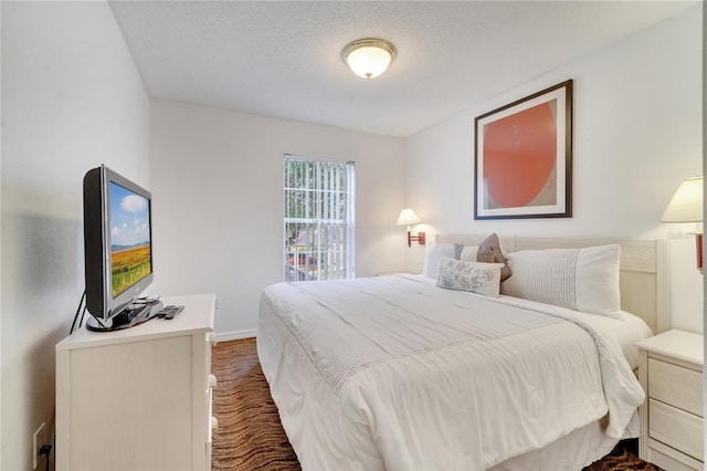 bedroom featuring a textured ceiling and baseboards