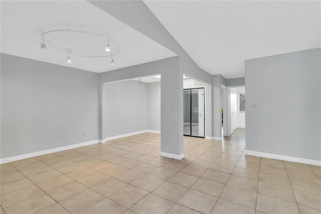 empty room with light tile patterned floors and baseboards