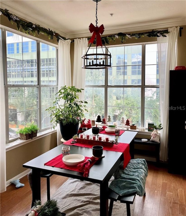 dining area with baseboards, a chandelier, and wood finished floors