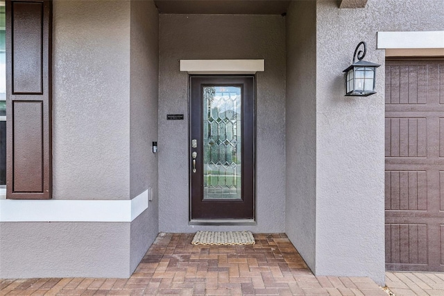 doorway to property featuring stucco siding