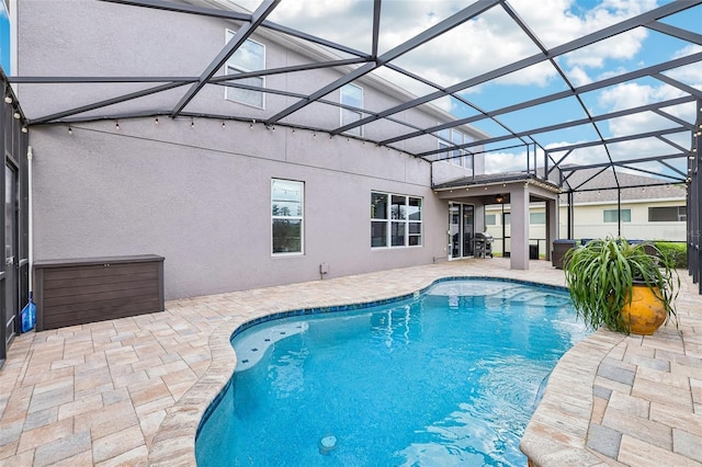 outdoor pool with a lanai and a patio area