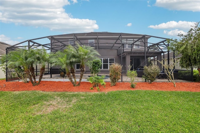 back of property with a patio area, glass enclosure, and a yard