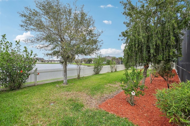 view of yard with a fenced backyard and a water view