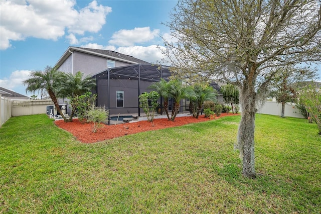 view of yard featuring glass enclosure and a fenced backyard