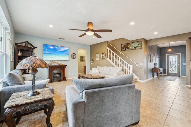 living area featuring stairs, light tile patterned flooring, visible vents, and baseboards