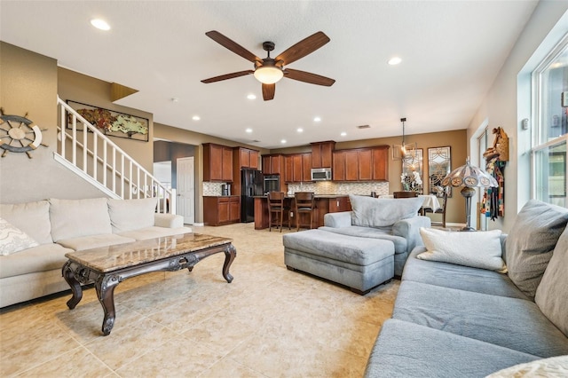 living room with a ceiling fan, recessed lighting, and stairs