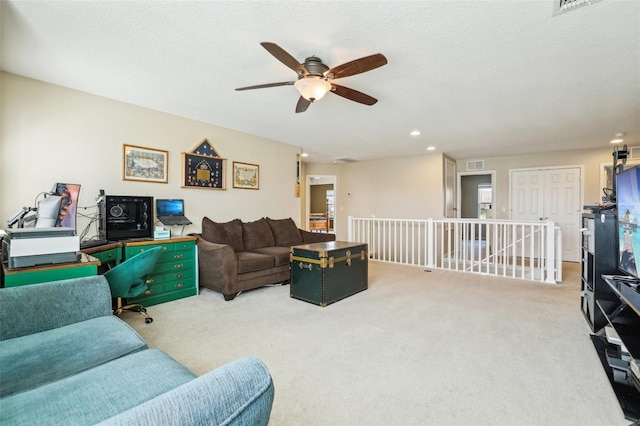 living room with light colored carpet, visible vents, a textured ceiling, and recessed lighting