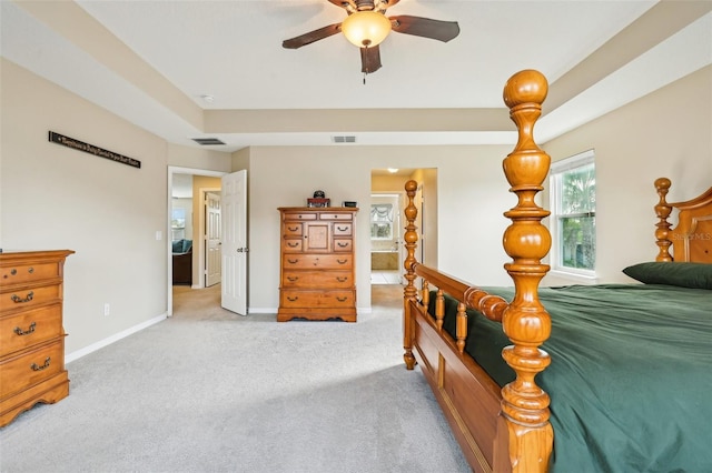 bedroom with light carpet, a ceiling fan, visible vents, and baseboards