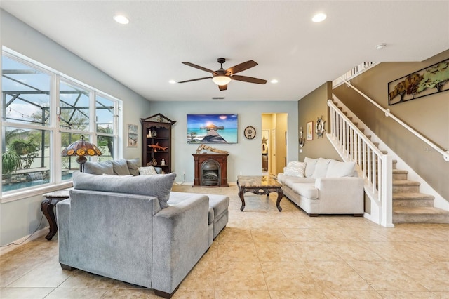 living area featuring ceiling fan, a fireplace, stairway, and recessed lighting