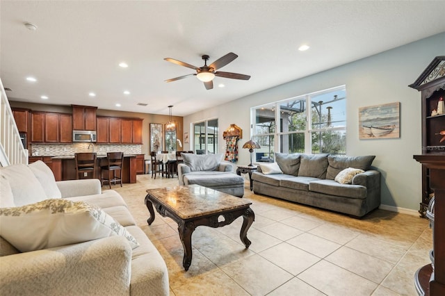 living room featuring recessed lighting, light tile patterned flooring, ceiling fan, and baseboards