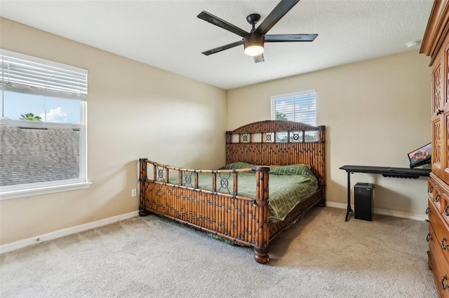 carpeted bedroom with ceiling fan and baseboards