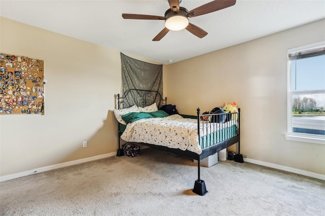 carpeted bedroom with ceiling fan and baseboards