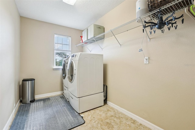 clothes washing area featuring laundry area, independent washer and dryer, and baseboards