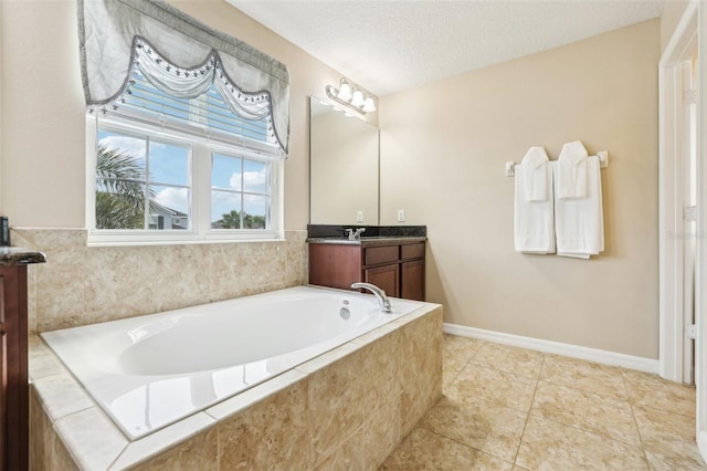 bathroom with a textured ceiling, a garden tub, vanity, baseboards, and tile patterned floors