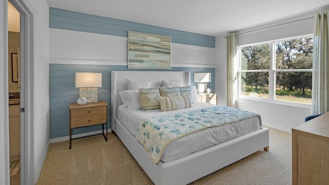 bedroom with wood walls, baseboards, and carpet flooring