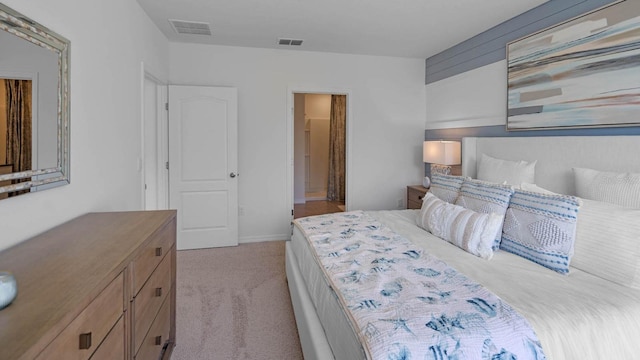 bedroom featuring visible vents and light colored carpet