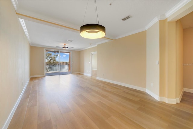 empty room featuring ornamental molding, visible vents, and light wood-style flooring