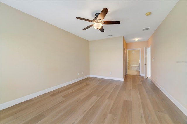 unfurnished room with light wood-style floors, visible vents, and baseboards