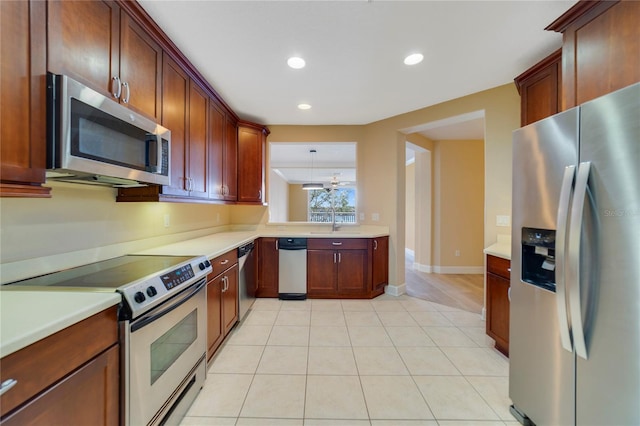 kitchen with light tile patterned floors, baseboards, stainless steel appliances, light countertops, and recessed lighting