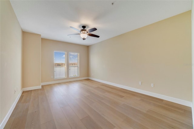 spare room with light wood-style floors, baseboards, and a ceiling fan