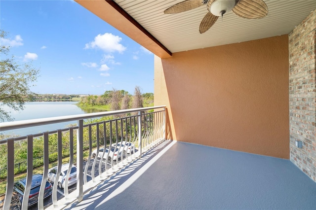 balcony featuring a water view and a ceiling fan