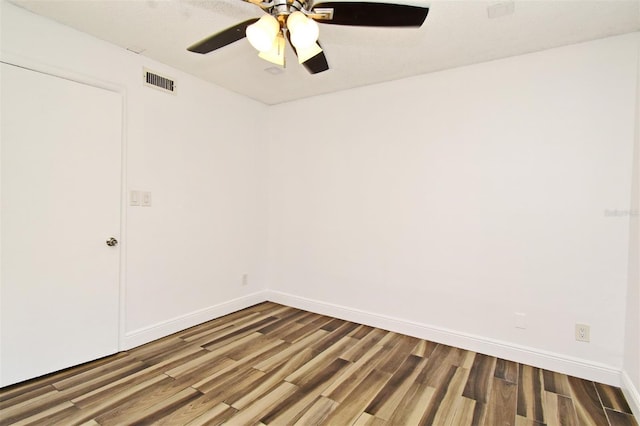 spare room with visible vents, baseboards, wood finished floors, and a ceiling fan