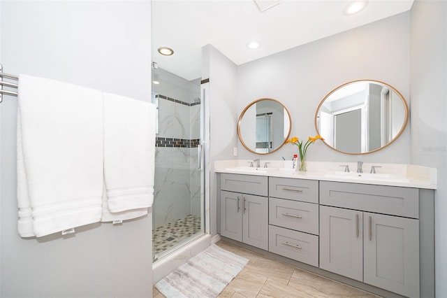 bathroom featuring a stall shower, a sink, and double vanity