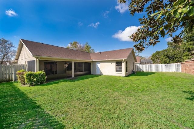 rear view of house with a fenced backyard and a lawn