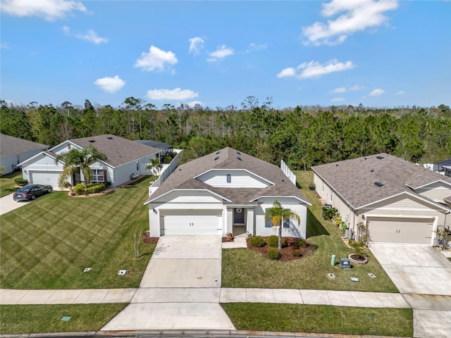 view of front of home featuring a front yard, concrete driveway, an attached garage, and stucco siding