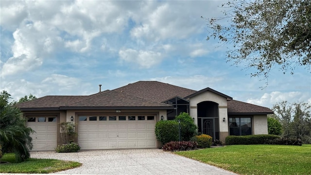 single story home featuring stucco siding, decorative driveway, roof with shingles, an attached garage, and a front yard