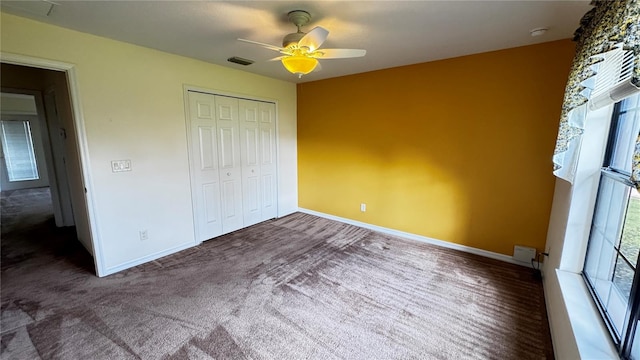 unfurnished bedroom with a closet, visible vents, carpet flooring, ceiling fan, and baseboards