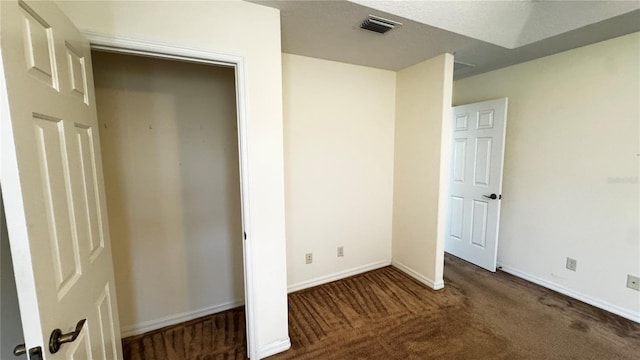 unfurnished bedroom featuring carpet, visible vents, and baseboards