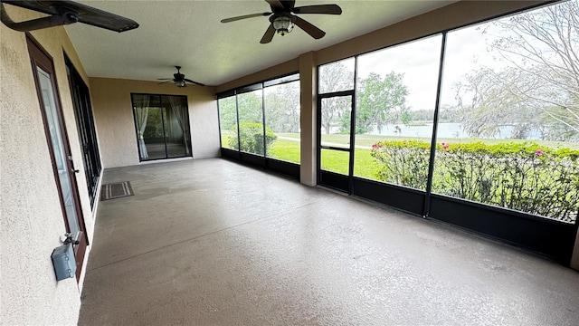 unfurnished sunroom with visible vents and a ceiling fan