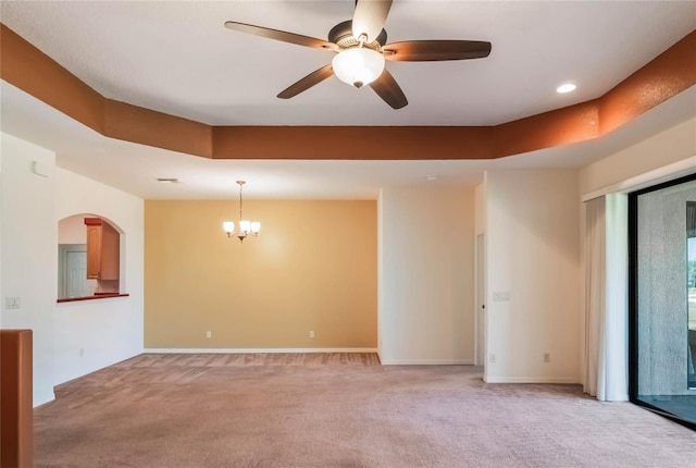 27307 Pine Straw Rd, Leesburg, FL 34748 - spare room with ceiling fan with notable chandelier, a tray ceiling, light colored carpet, and baseboards
