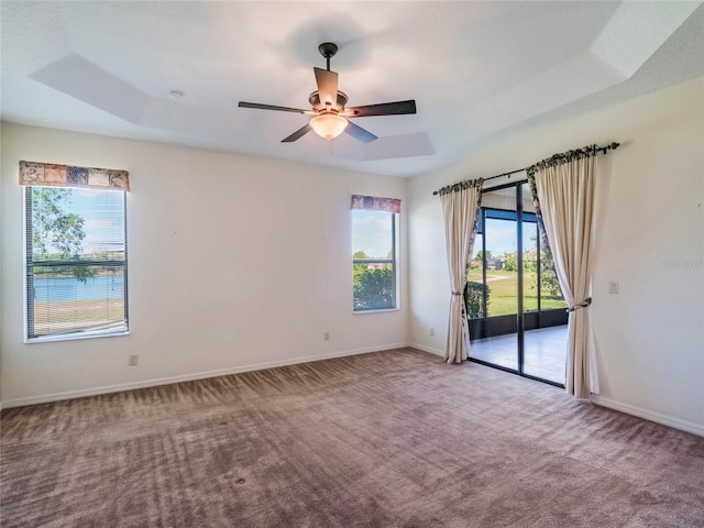 27307 Pine Straw Rd, Leesburg, FL 34748 - carpeted empty room with a ceiling fan, a raised ceiling, and baseboards
