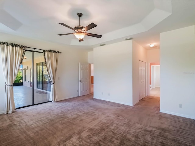 27307 Pine Straw Rd, Leesburg, FL 34748 - carpeted spare room featuring a tray ceiling, baseboards, visible vents, and ceiling fan