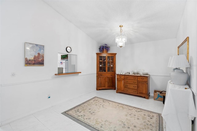 dining area featuring a textured ceiling, a notable chandelier, and light tile patterned flooring