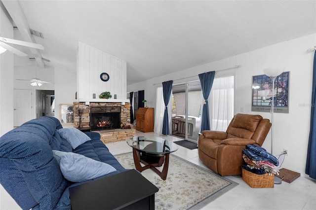 living area featuring vaulted ceiling with beams, light tile patterned floors, visible vents, and a stone fireplace