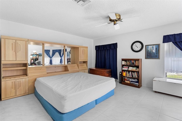 bedroom with visible vents, ceiling fan, and a textured ceiling