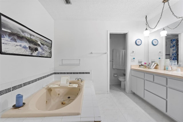 bathroom with toilet, vanity, a textured ceiling, a whirlpool tub, and tile patterned floors