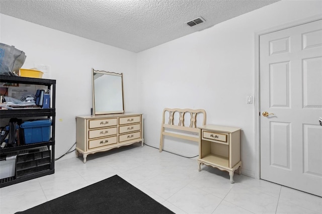 bedroom with a textured ceiling and visible vents