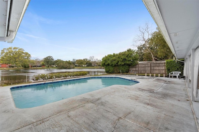 outdoor pool featuring a water view, a patio, and fence