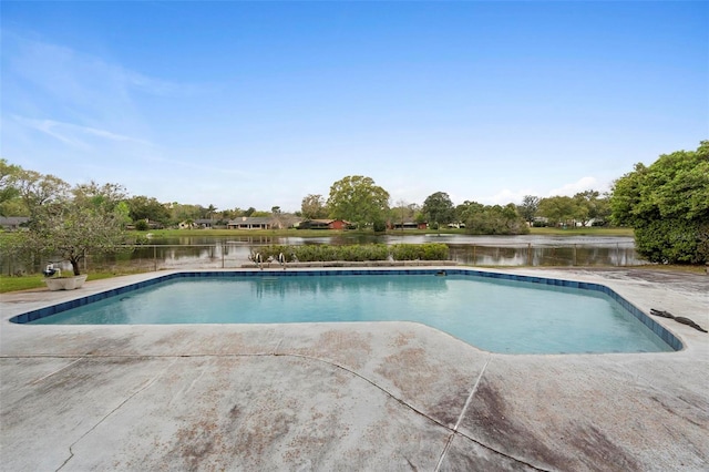 outdoor pool with a water view and a patio area