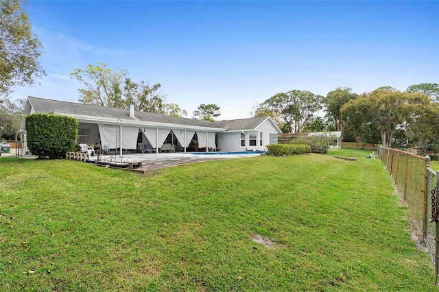 back of house with a fenced in pool, a fenced backyard, a lawn, and a patio