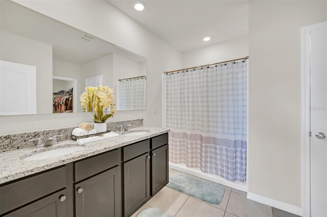 full bath featuring double vanity, a sink, a shower with shower curtain, and tile patterned floors