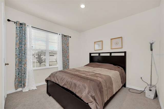 bedroom with baseboards and light colored carpet