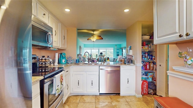 kitchen with a ceiling fan, stainless steel appliances, white cabinetry, a sink, and recessed lighting