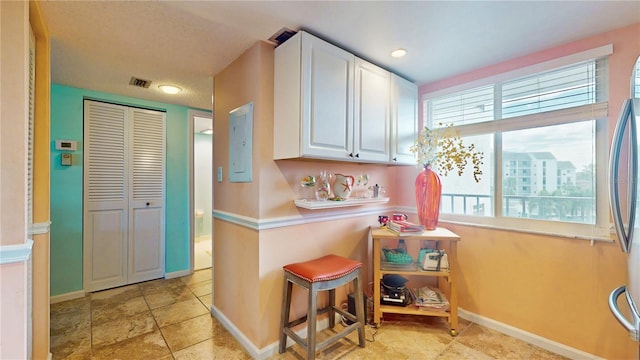 kitchen featuring baseboards, visible vents, white cabinets, and light countertops